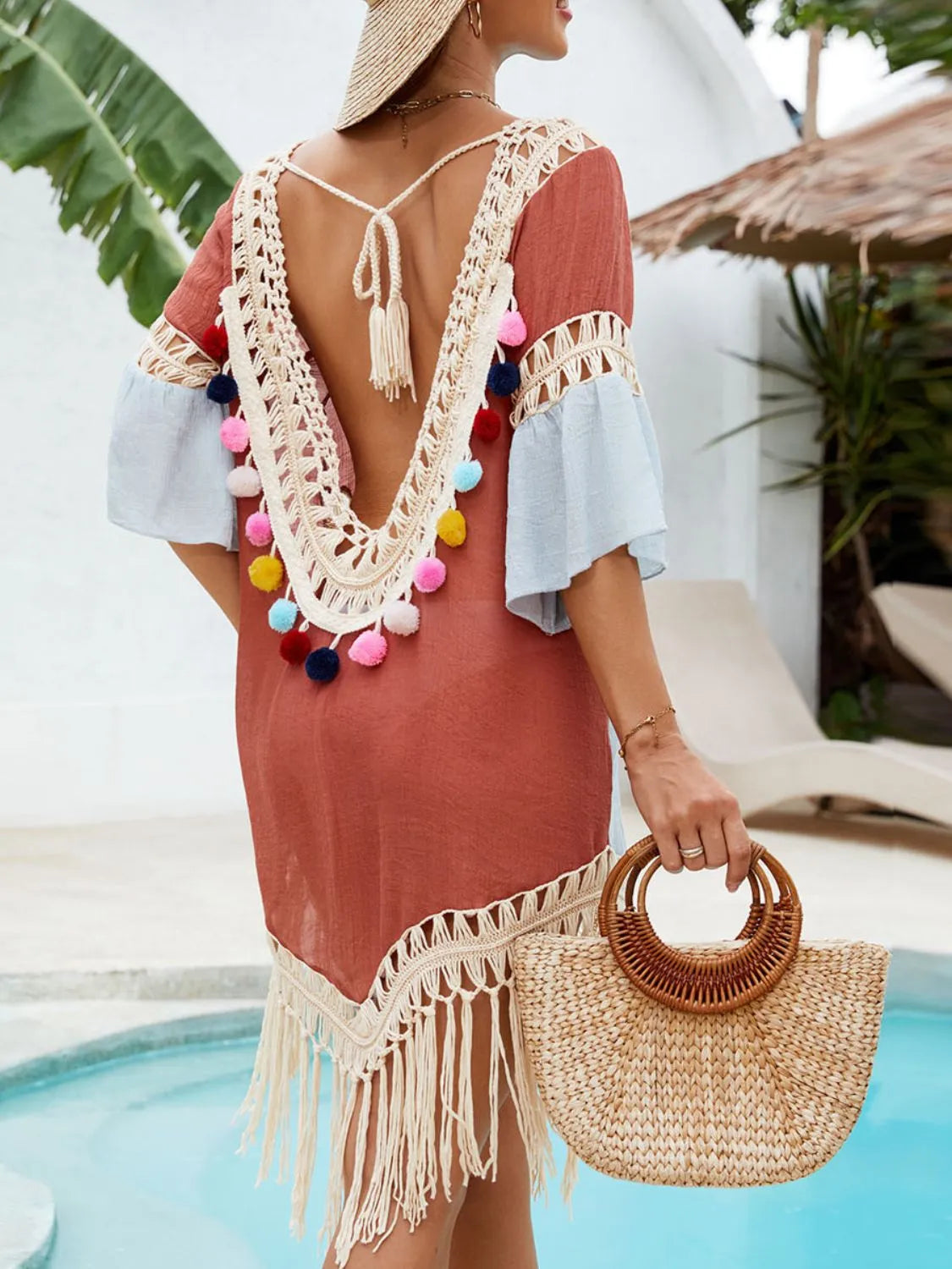 Close-up of fringe and tassel hem detail on terracotta swim cover-up
