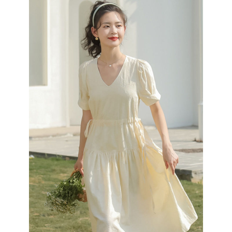 Petite Girls French Tea Break dress features a V-neck, drawstring-style neckline, elastic waist, commuting and office-style skirt silhouette, short sleeve, pleated midi-length skirt, solid-colored pattern,